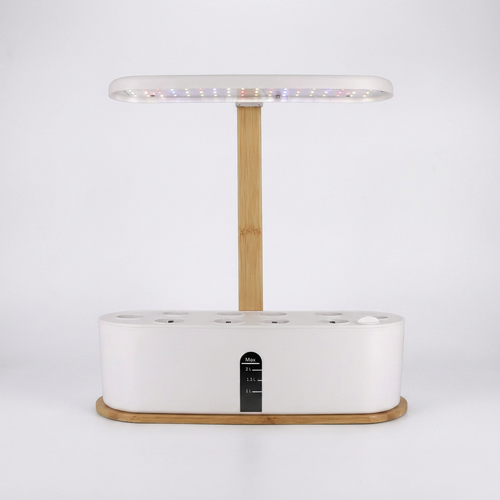Hydroponic plant growing system with LED light and bamboo base, studio shot on white background
